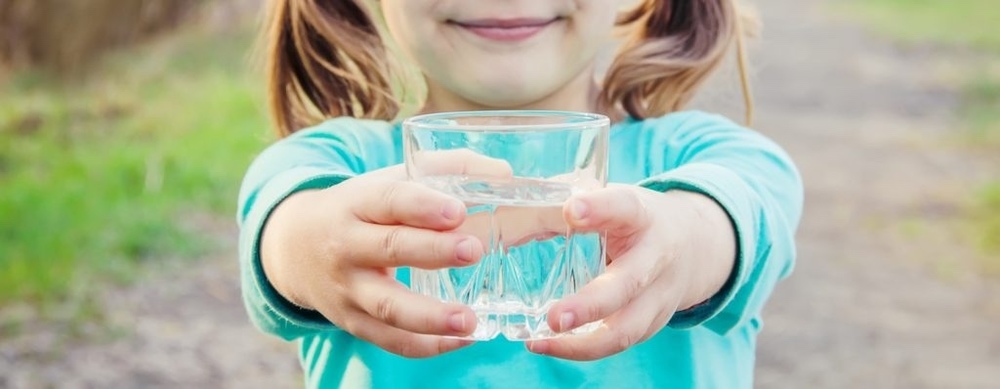 child holding a glass of water